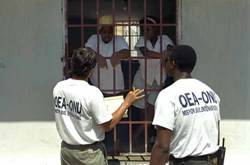 [Image: In Port-au-Prince, International Civilian Mission observers talking with Haitian prisoners about their cases. UN Photo# 187347C]